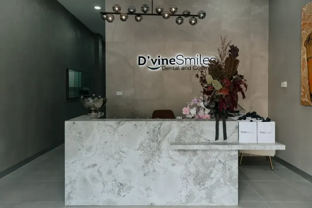 Front desk with a D'vine Smiles logo sign on the wall